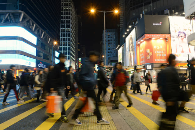 수많은 사람들이 화려한 불빛 사이로 홍콩의 밤거리를 걷고 있다.