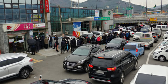 28일 오후 김해주촌우체국 앞에 마스크를 사기 위해 시민들과 차량이 몰려 있다./조규홍 기자/