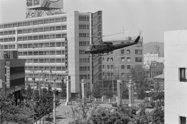 1980년 5월 21일 전일빌딩 앞을 날고 있는 UH-1 헬기(위)와 ‘증강현실(AR) 디바이스’를 통해 살펴보는 가상의 헬기사격 모습.