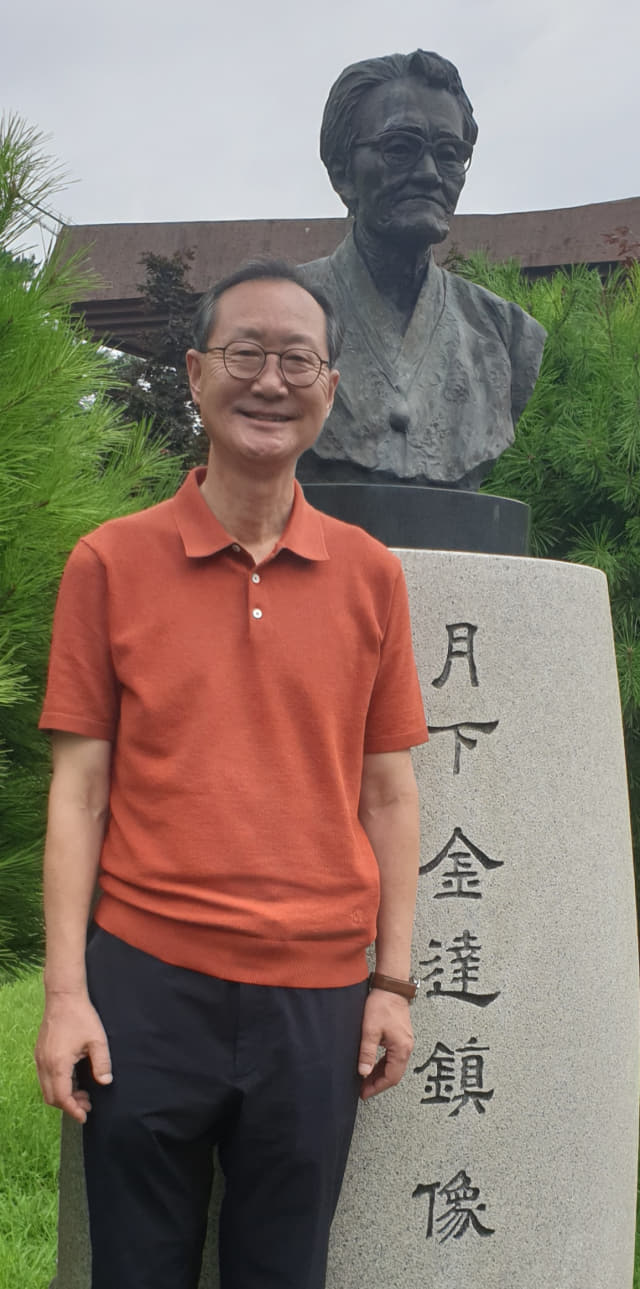 이성모 김달진문학관 관장이 문학관 정원에 있는 김달진 선생 흉상 앞에서 환하게 웃고 있다.
