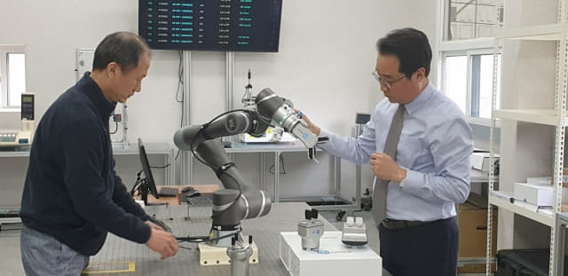 김영남(오른쪽) 대표가 사내 연구원과 함께 스마트 MES에 적용되는 협동로봇에 대한 얘기를 나누고 있다.