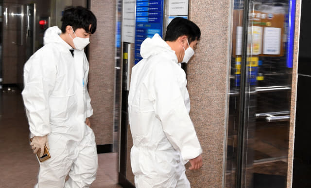 보호복을 입은 방역당국 관계자들이 엘리베이터를 타고 병원으로 들어가고 있다./경남신문 자료사진/