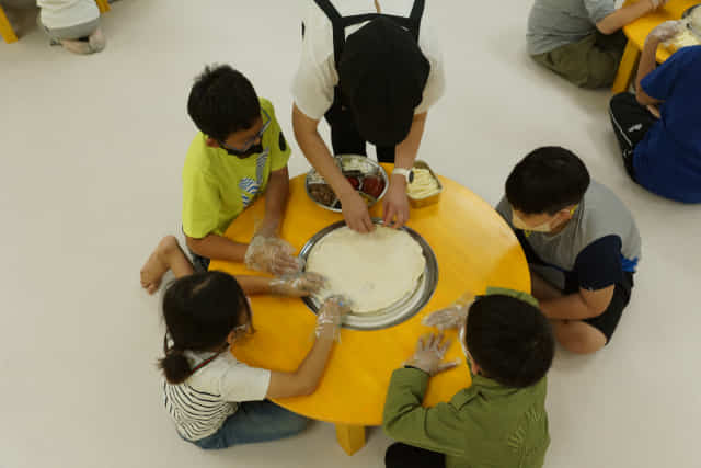김해 회현연가 치즈스토리에서 아이들이 치즈와 피자 만들기 체험을 하고 있다.