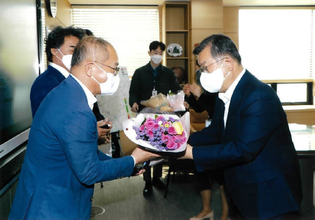 권 대표가 성금을 전달 후 박일호 시장으로부터 감사 꽃다발을 받고 있다.