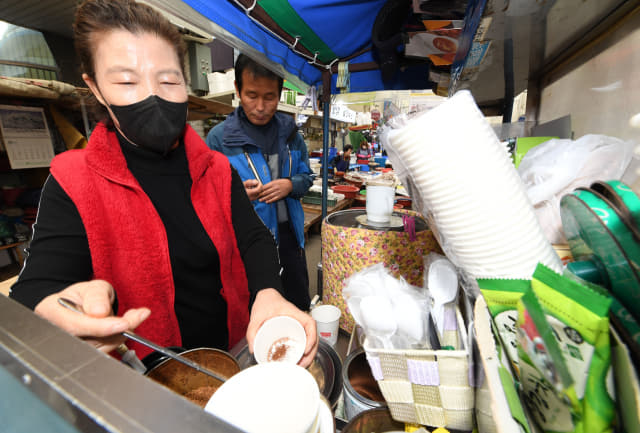 어시장에서 36년째 리어카를 밀며 커피를 팔고 있는 김종숙씨가 커피를 타고 있다.