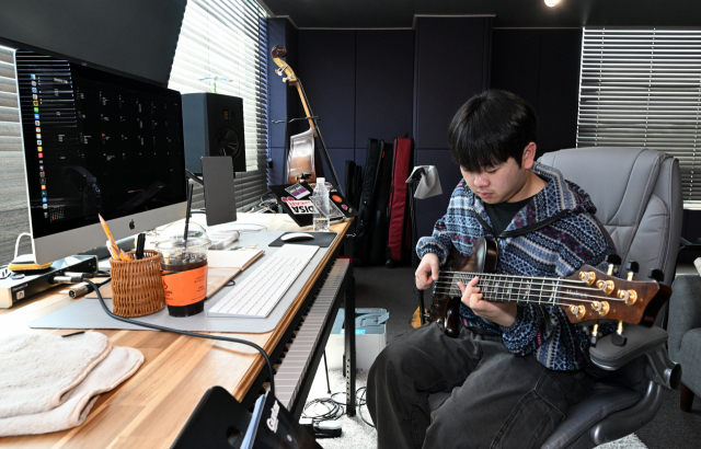 최형석 베이시스트가 김해시 진영읍 자신의 작업실에서 베이스 기타를 연주하고 있다./성승건 기자/